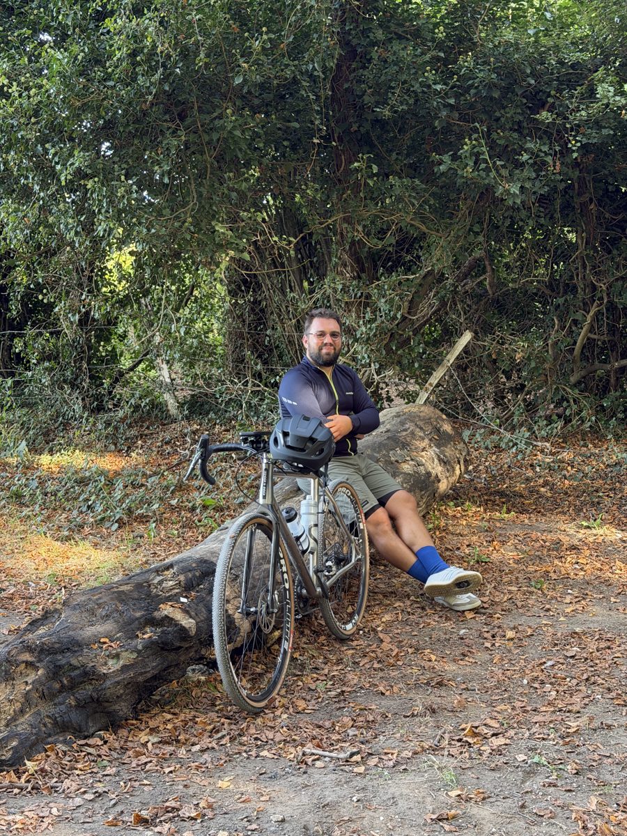 Daniil resting by his gravel bike in the woods